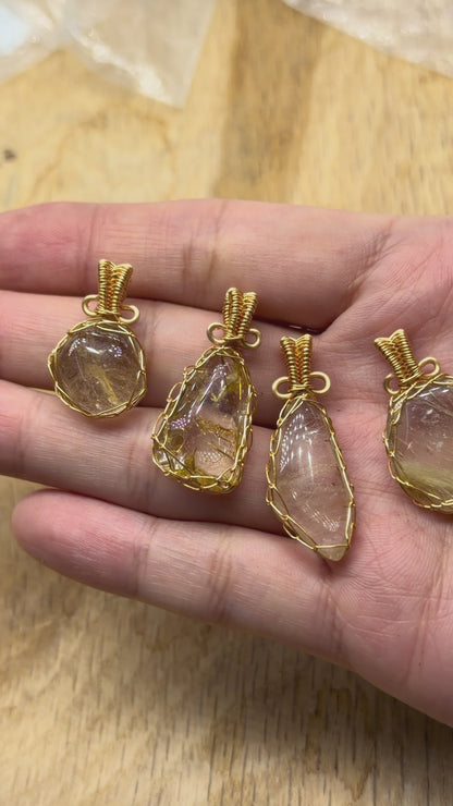 Rutilated quartz pendant, irregular shape — Gold-plated brass wire setting